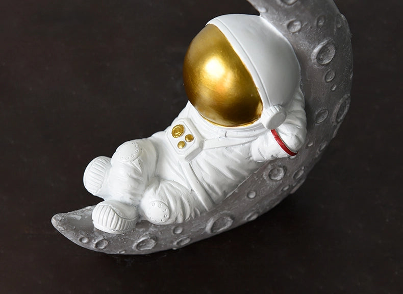 رائد فضاء جالس من الراتنج في الفضاء والزمن - مستلقٍ باللون الذهبي