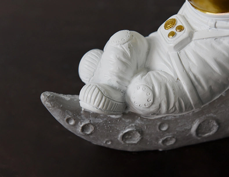 رائد فضاء جالس من الراتنج في الفضاء والزمن - مستلقٍ باللون الذهبي