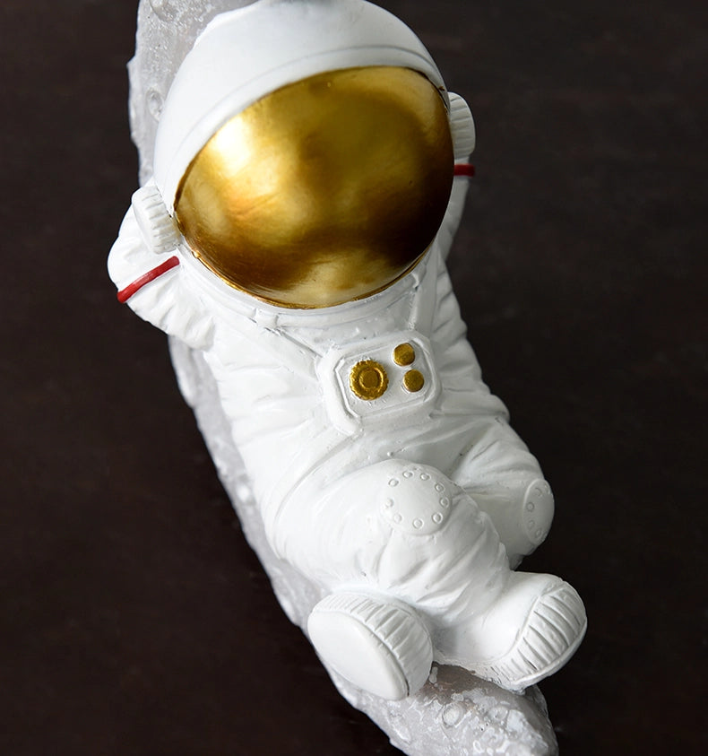 رائد فضاء جالس من الراتنج في الفضاء والزمن - مستلقٍ باللون الذهبي